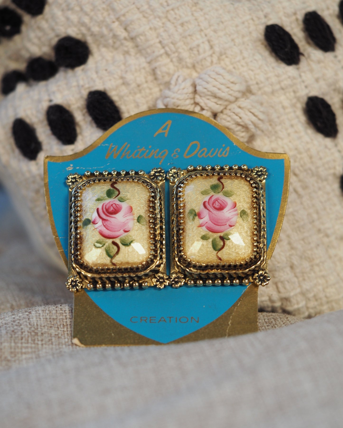 Front view of both earrings still mounted on original turquoise Whiting & Davis 'A Creation' presentation card