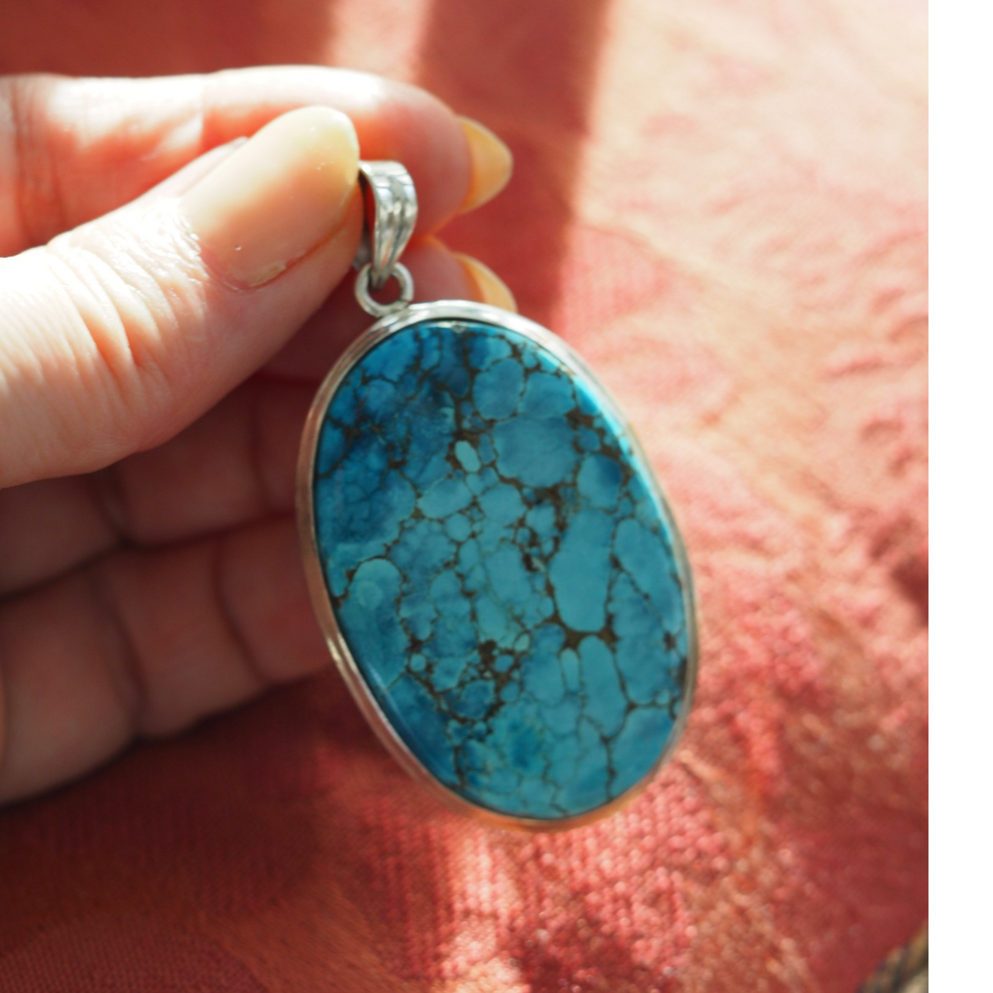 Large turquoise statement pendant shown in hand for scale
