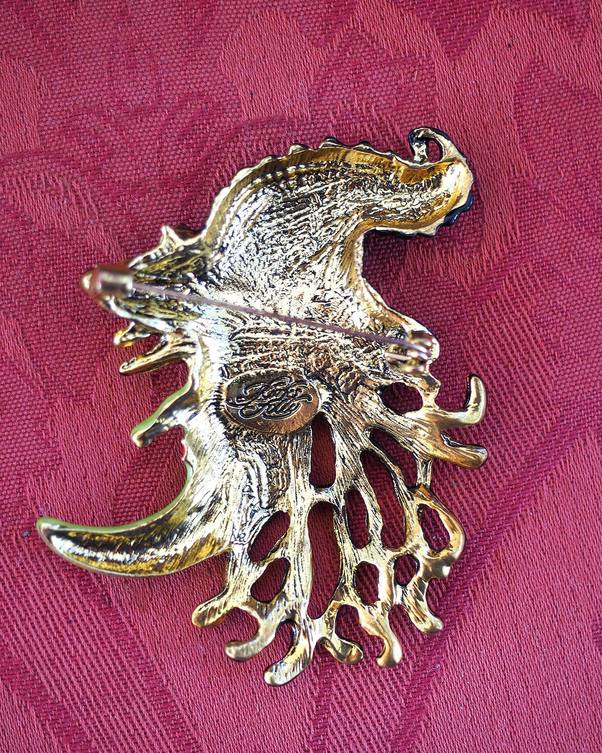 Back of Kirks Folly witch brooch on pink fabric