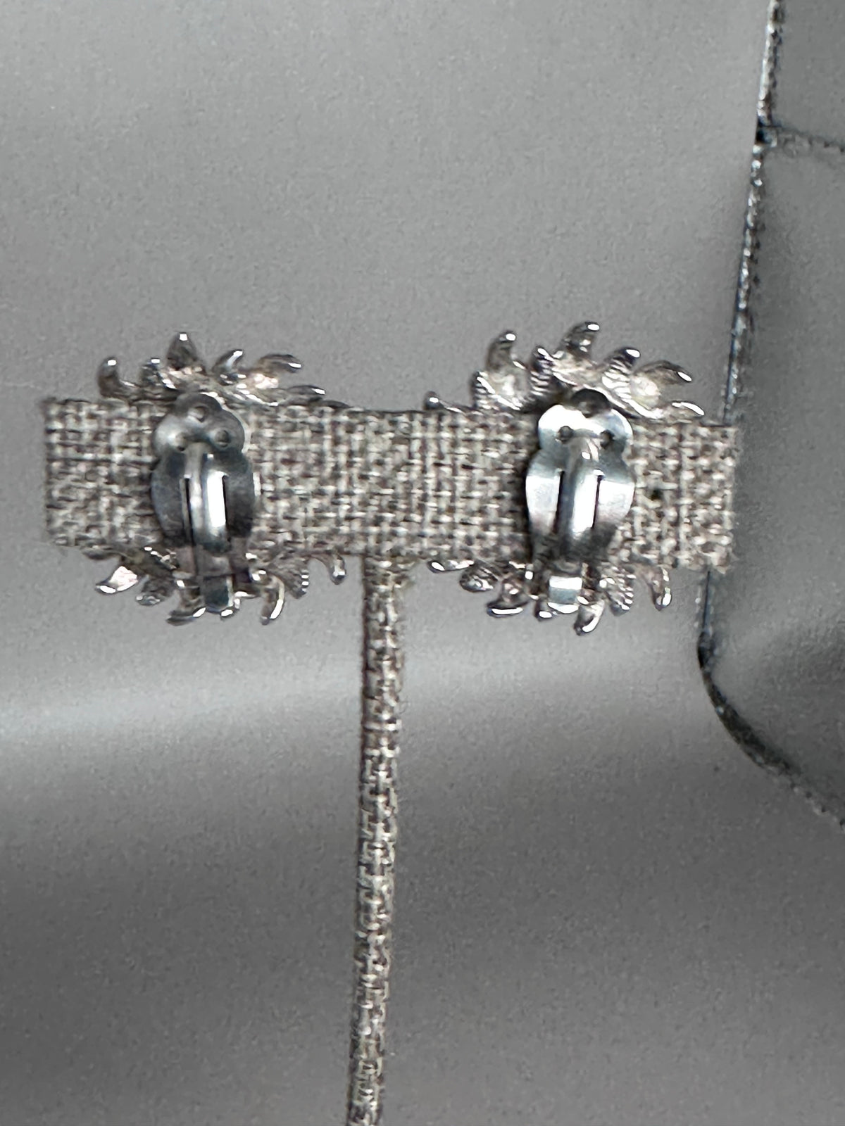 Back view of sterling silver Taxco sun earrings showing hinged clip-on mechanisms and open-back construction