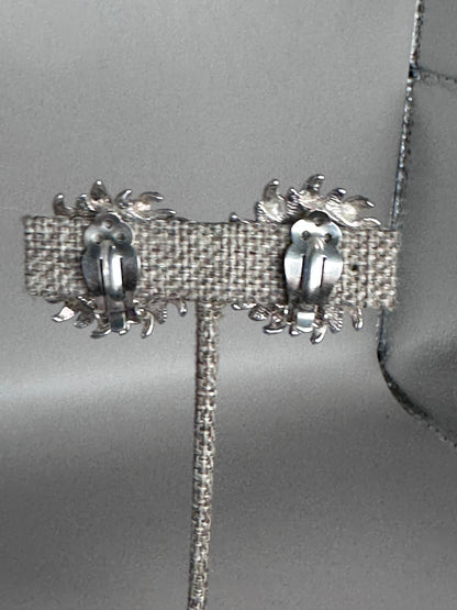Back view of sterling silver Taxco sun earrings showing hinged clip-on mechanisms and open-back construction