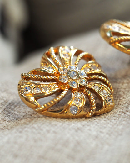 side angle showing the dimensional openwork construction and layered petal relief in warm gold tone