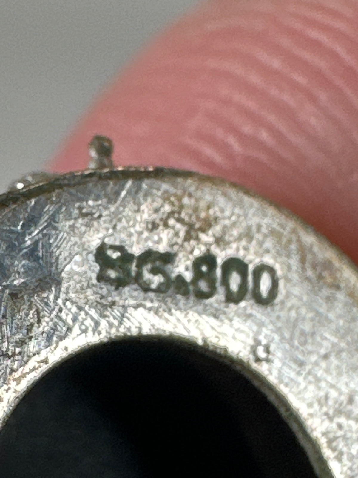 extreme close-up of BC800 hallmark stamped on interior of clip mechanism back