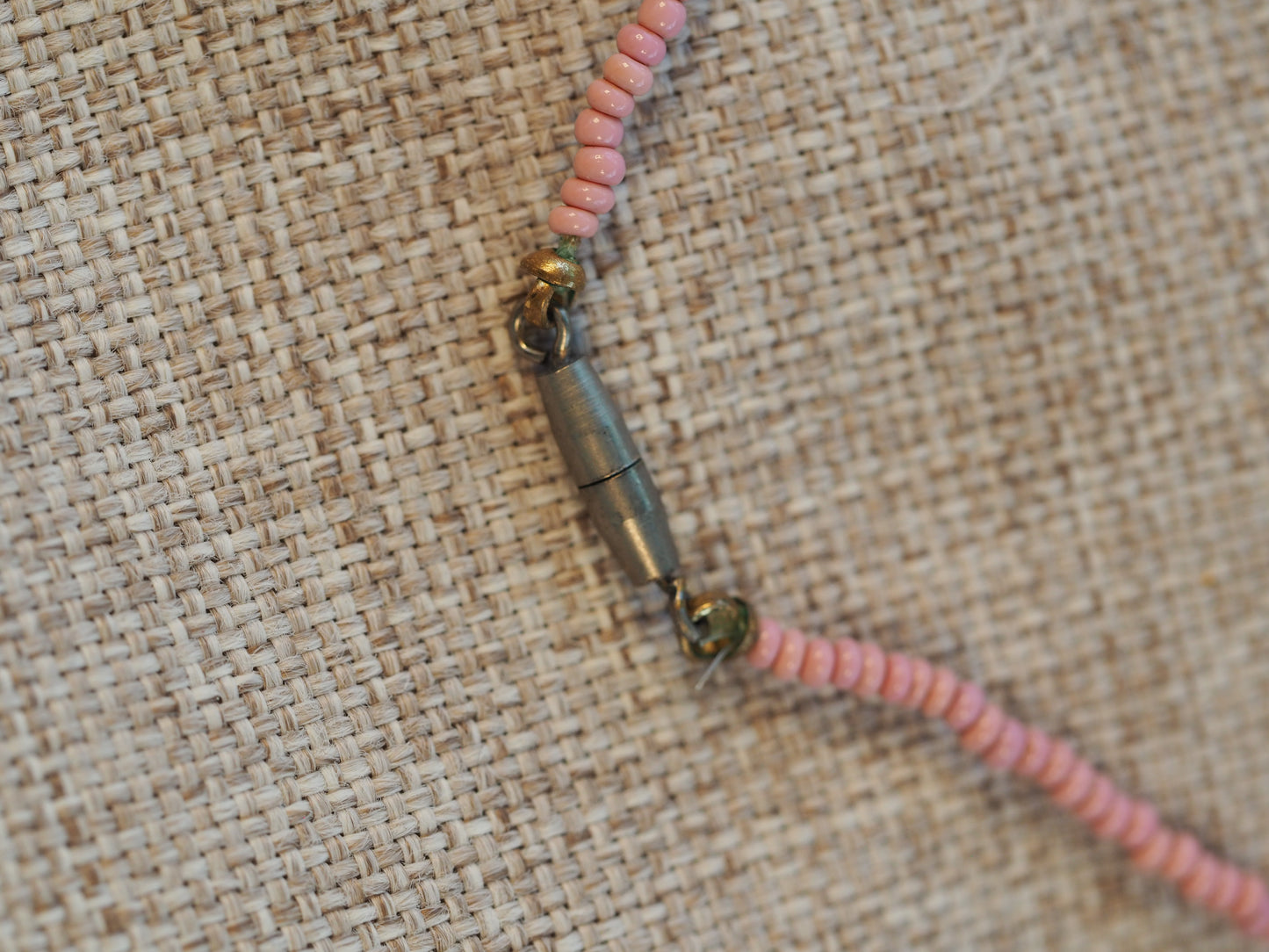Close-up of the screw barrel clasp in base metal with pink seed beads