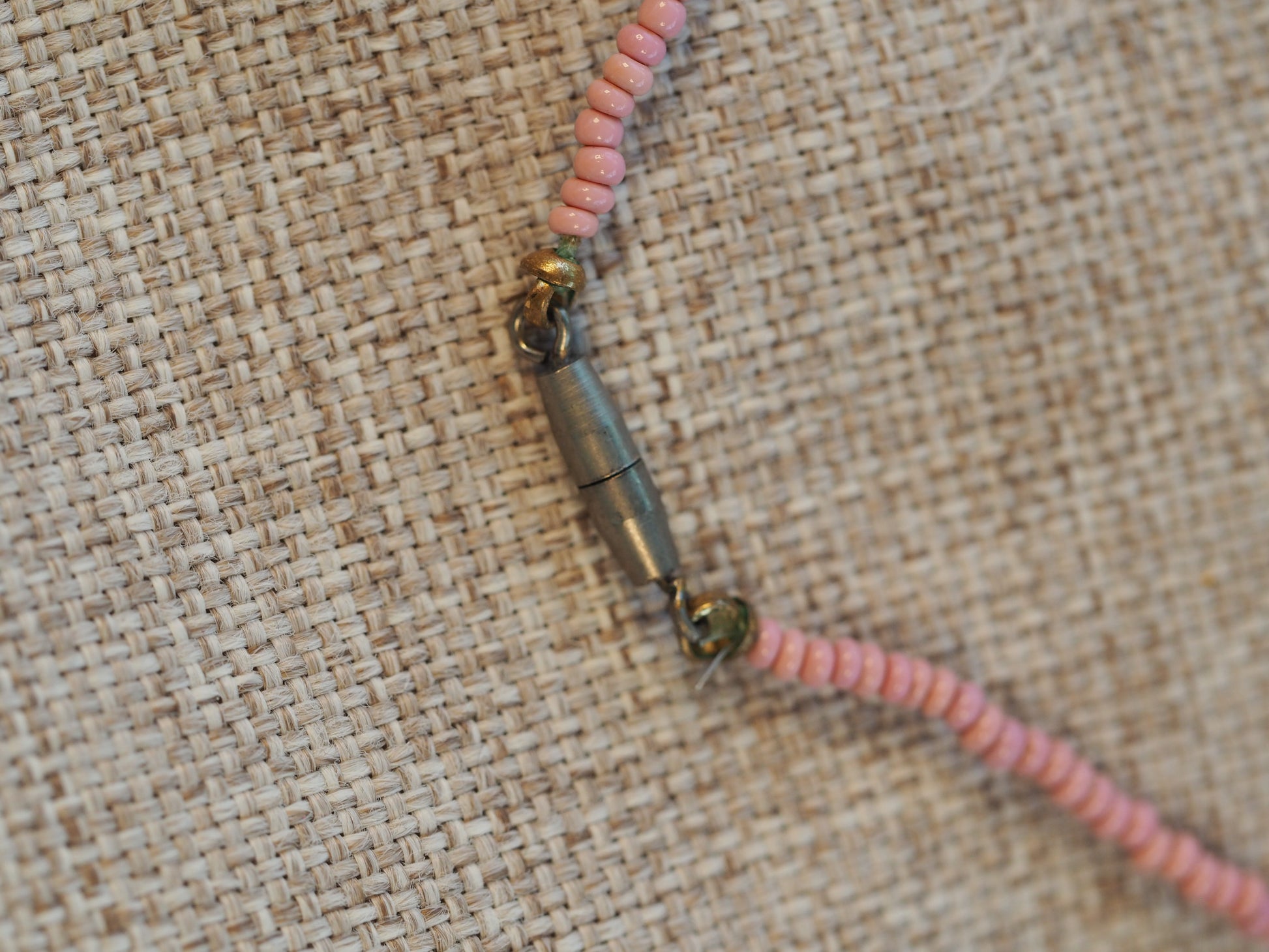 Close-up of the screw barrel clasp in base metal with pink seed beads