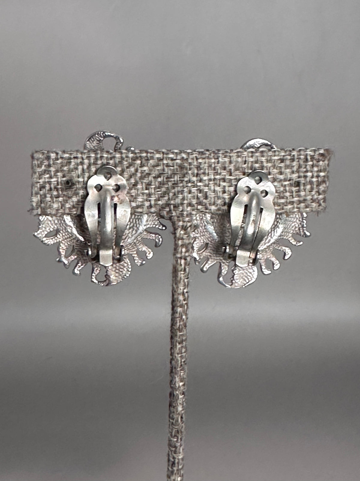 Reverse view of the sterling silver Taxco sun and moon clip earrings showing the rounded clip-on backs with comfort pads