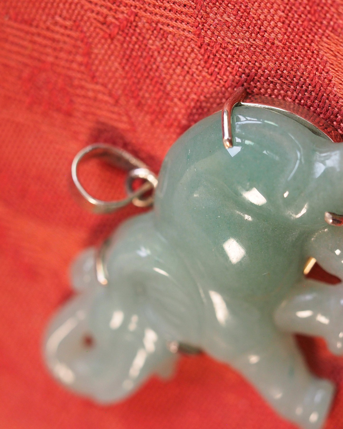 Close-up of sterling silver bail and prong mounts on aventurine elephant pendant, showing 925 stamp and secure attachment