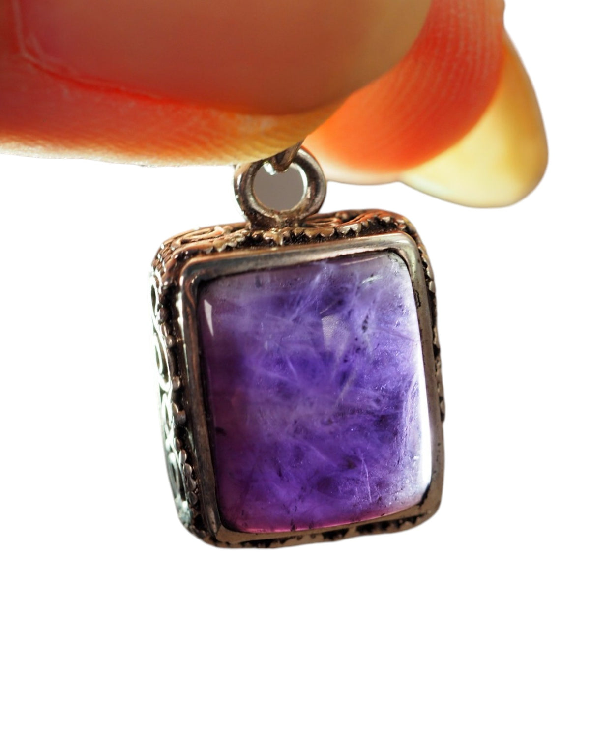 Front view of rectangular amethyst pendant in sterling silver with openwork detail, suspended from orange ribbon