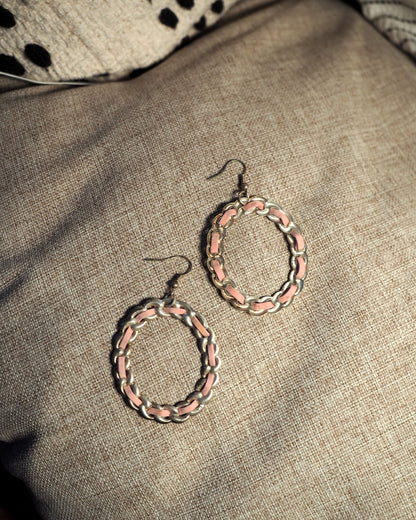 Pair of 1970s pink and silver-tone enamel chainlink hoop earrings on linen, full view showing both hoops and wire hooks
