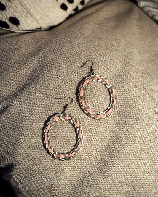 Pair of 1970s pink and silver-tone enamel chainlink hoop earrings on linen, full view showing both hoops and wire hooks