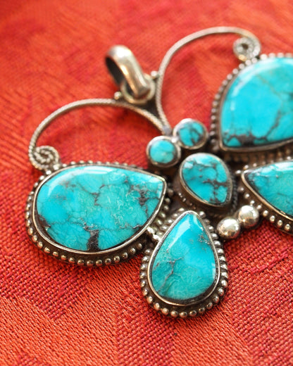 Close-up of turquoise cabochons with dark matrix pattern and beaded sterling silver borders