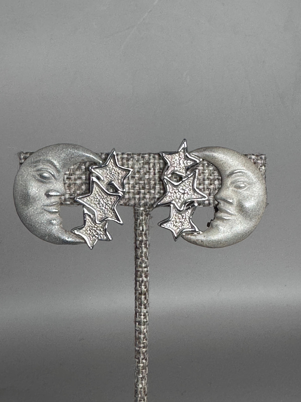 Sterling silver Taxco moon and stars clip earrings front view, showing crescent moon faces with closed eyes and three graduated stars on each