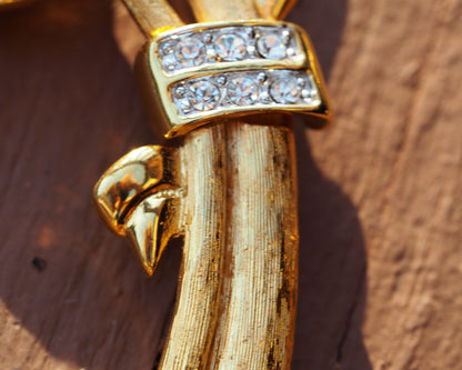 Side view of stem showing brushed gold-tone texture and rhinestone-set ribbon detail