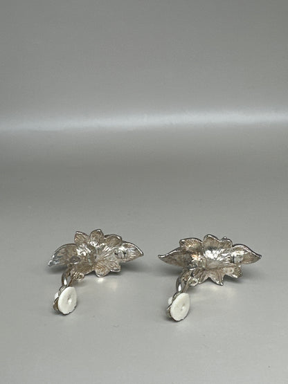 Clip earrings photographed flat showing backs with clip mechanisms and individual leaf assembly