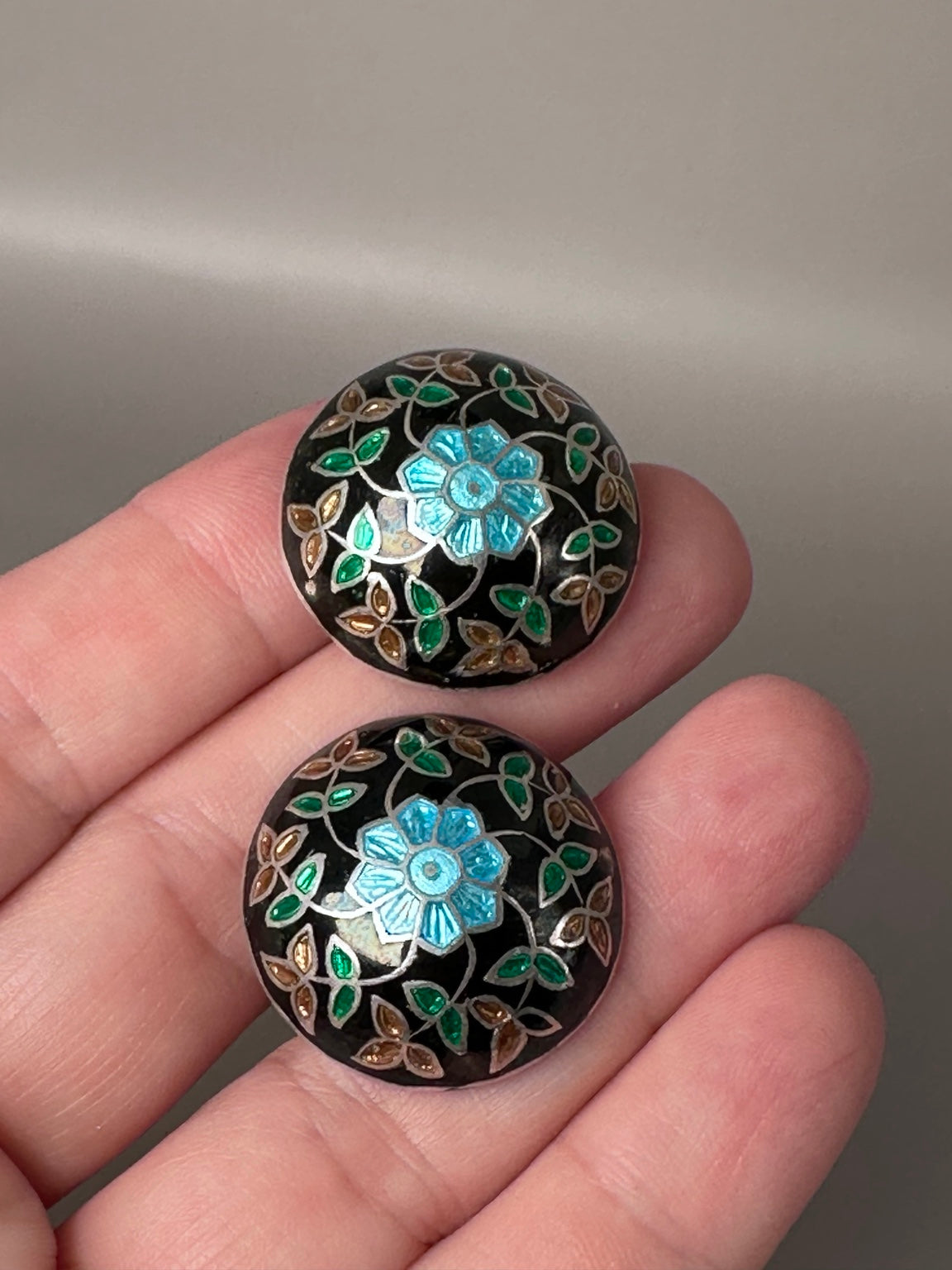 Vintage sterling silver floral dome earrings shown in hand for scale