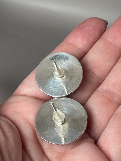 Reverse of vintage sterling silver floral stud earrings shown in hand