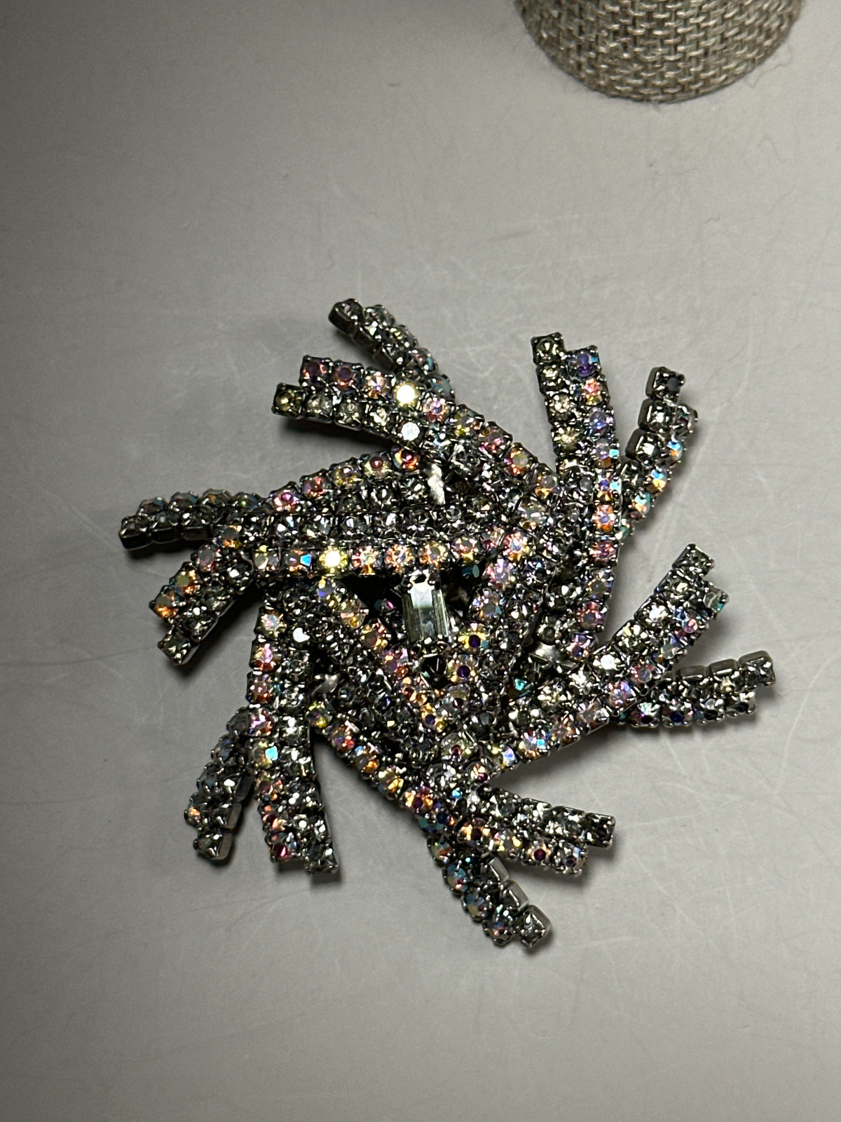 Starburst brooch flat lay showing full dimensional sculptural form with emerald-cut smoky center stone