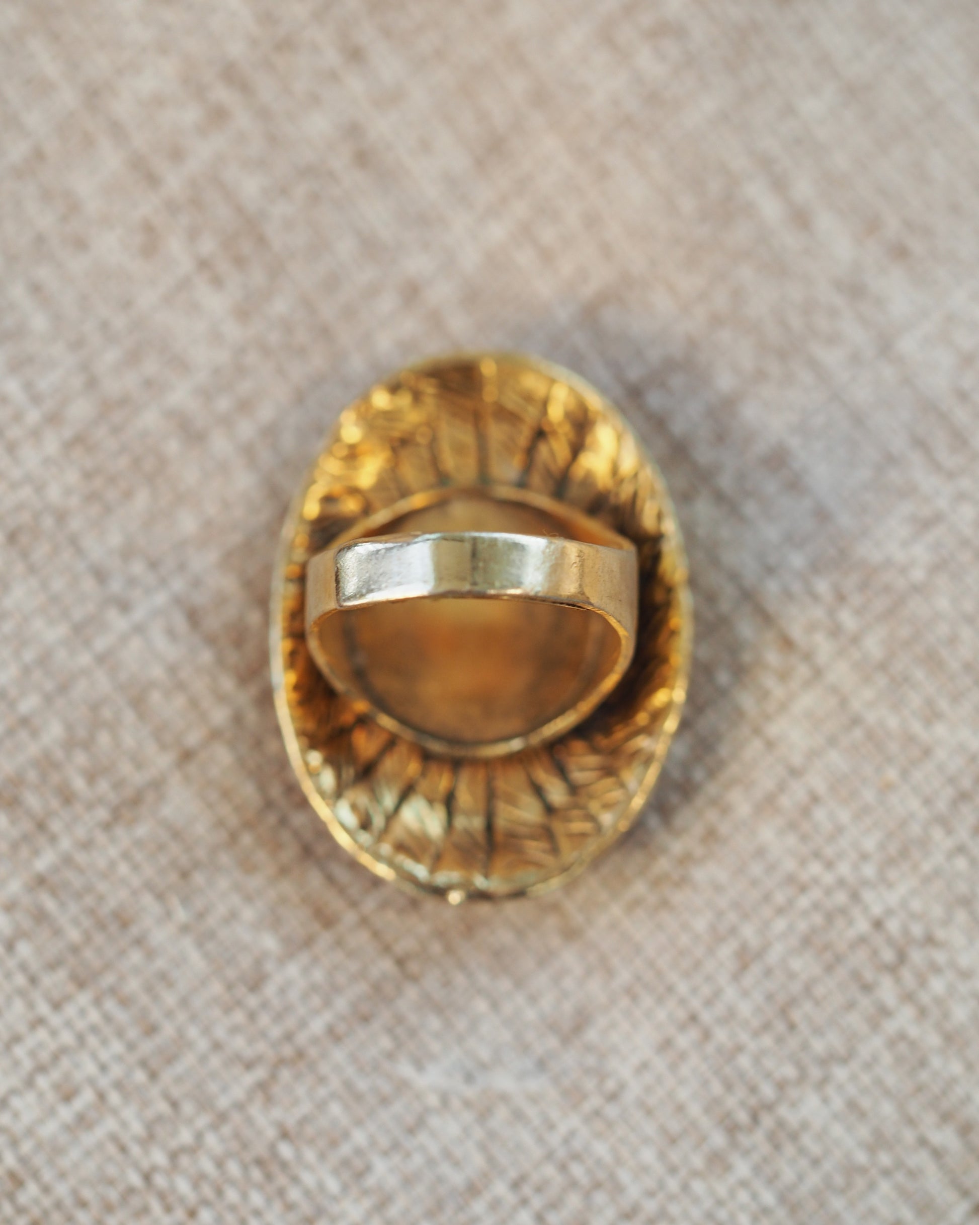 Reverse view of adjustable ring shank showing split band and plain interior, gold-tone finish