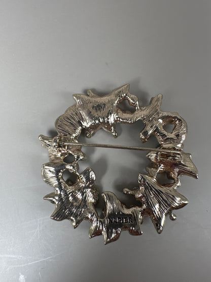 Reverse of Napier enamel brooch showing textured gold-tone radiating petal backing with NAPIER stamp and C-clasp pin mechanism