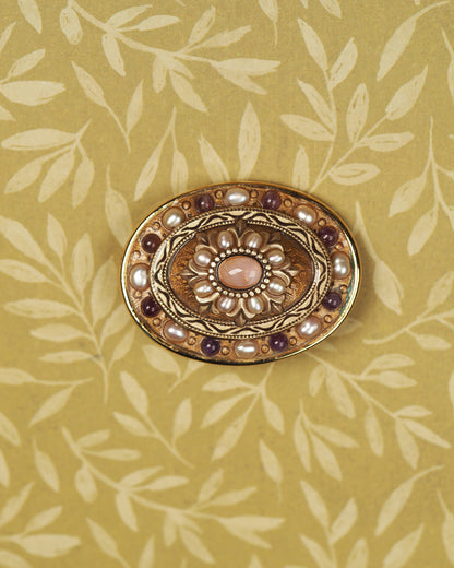 Signed Michal Golan gold-tone brooch with rose-colored quartz center, pearl-like petals, and purple accents, front view