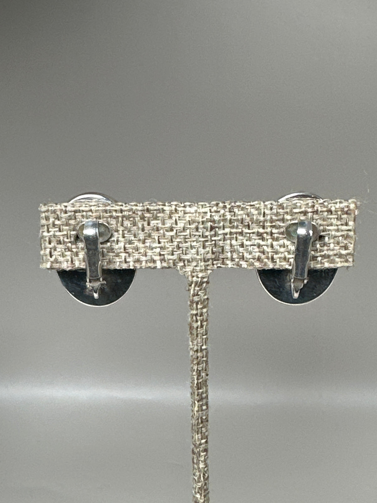 Earring backs showing hinged clip-on mechanisms with tension springs