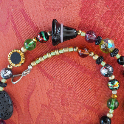 Detail of black glass cone bead and multicolor spatter-pattern glass beads near hook clasp
