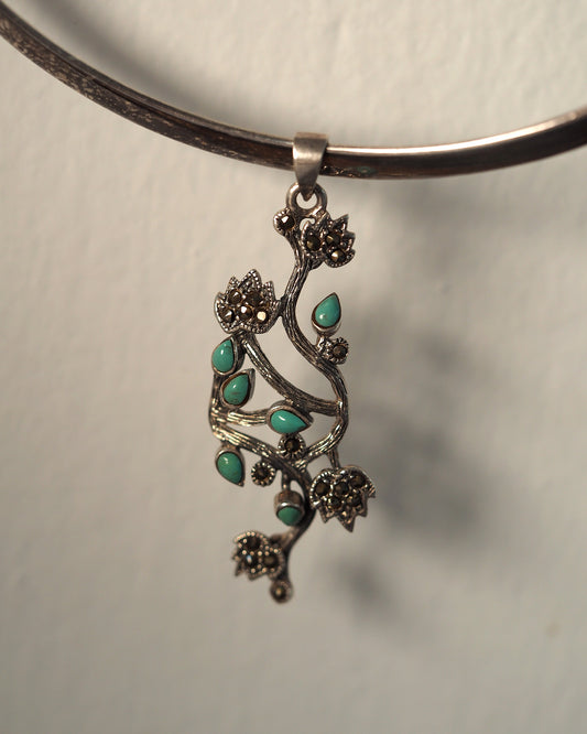 Sterling silver vine pendant with turquoise cabochons and marcasite floral clusters, front view on black cord
