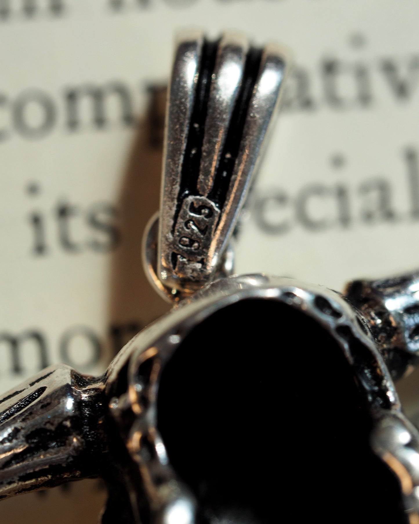 Close-up of the 925 sterling silver hallmark stamped on the ribbed bail