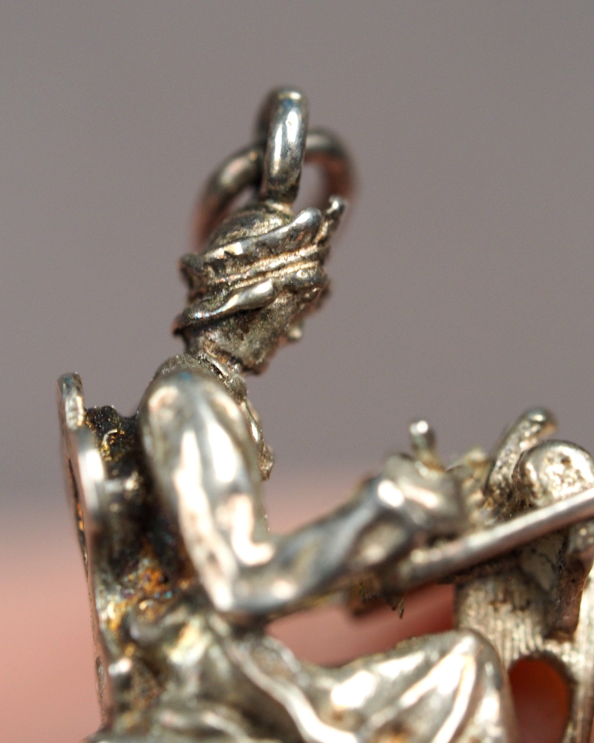 close-up of split-ring bail and head detail showing aged patina in hair texture