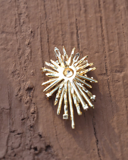 Back view of one starburst earring showing clean gold finish, post attachment, and domed center