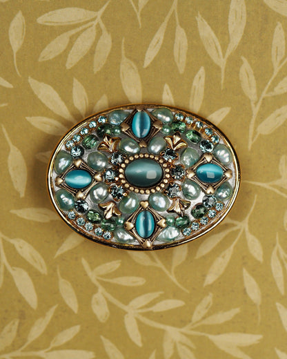 Michal Golan oval brooch with teal catseye cabochons and crystals in gold-tone lattice, front view