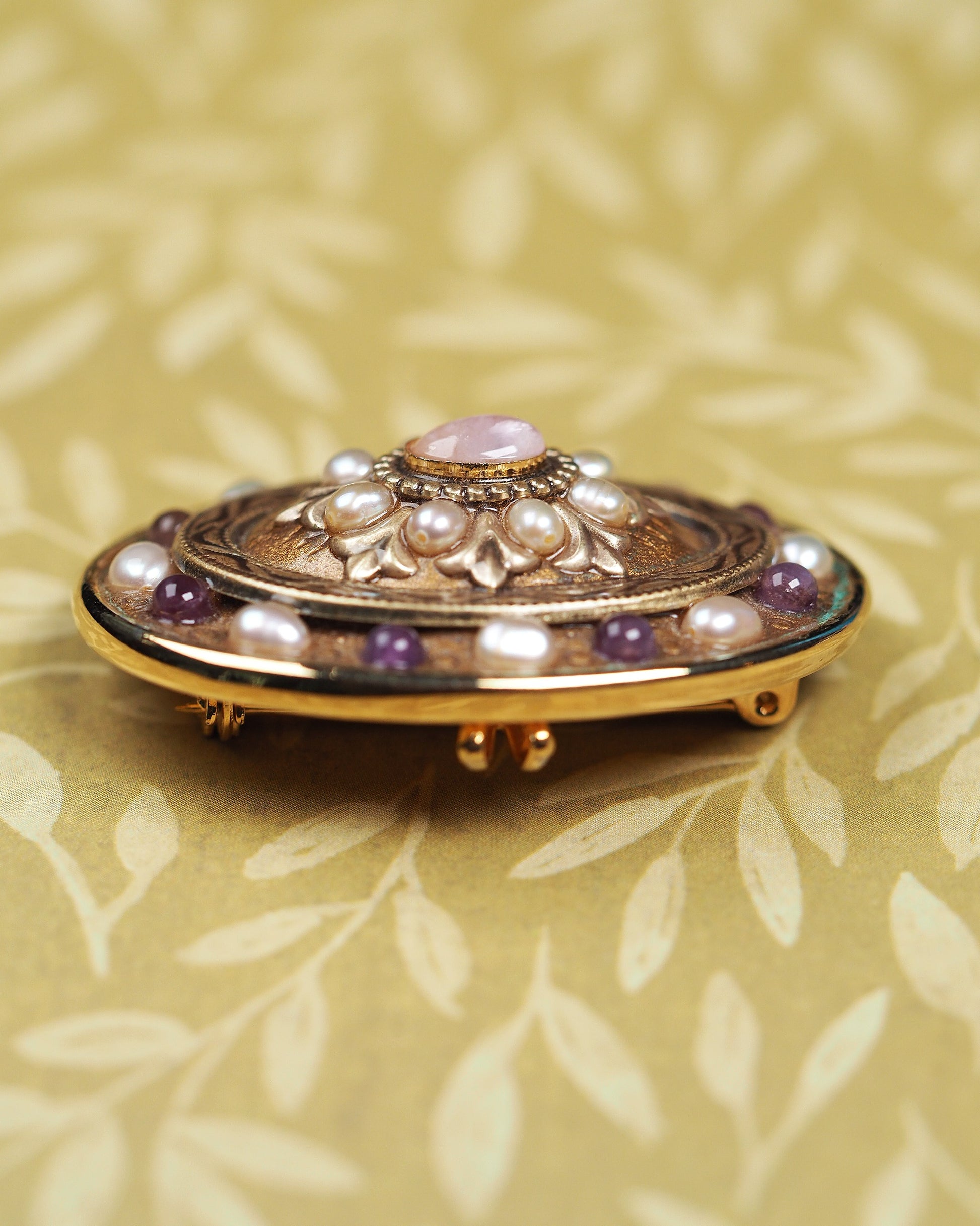 Side profile of collectible Michal Golan brooch showing dimensional layered construction and raised bezels