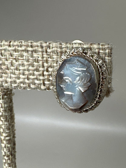 close-up of mother-of-pearl cameo showing carving detail and notched silver bezel frame