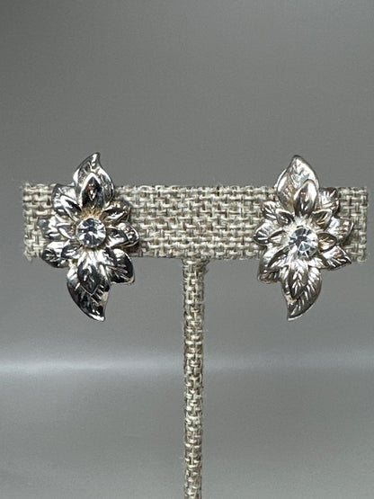 Close-up front view of rhinestone-centered leaf spray earrings highlighting prong-set stones