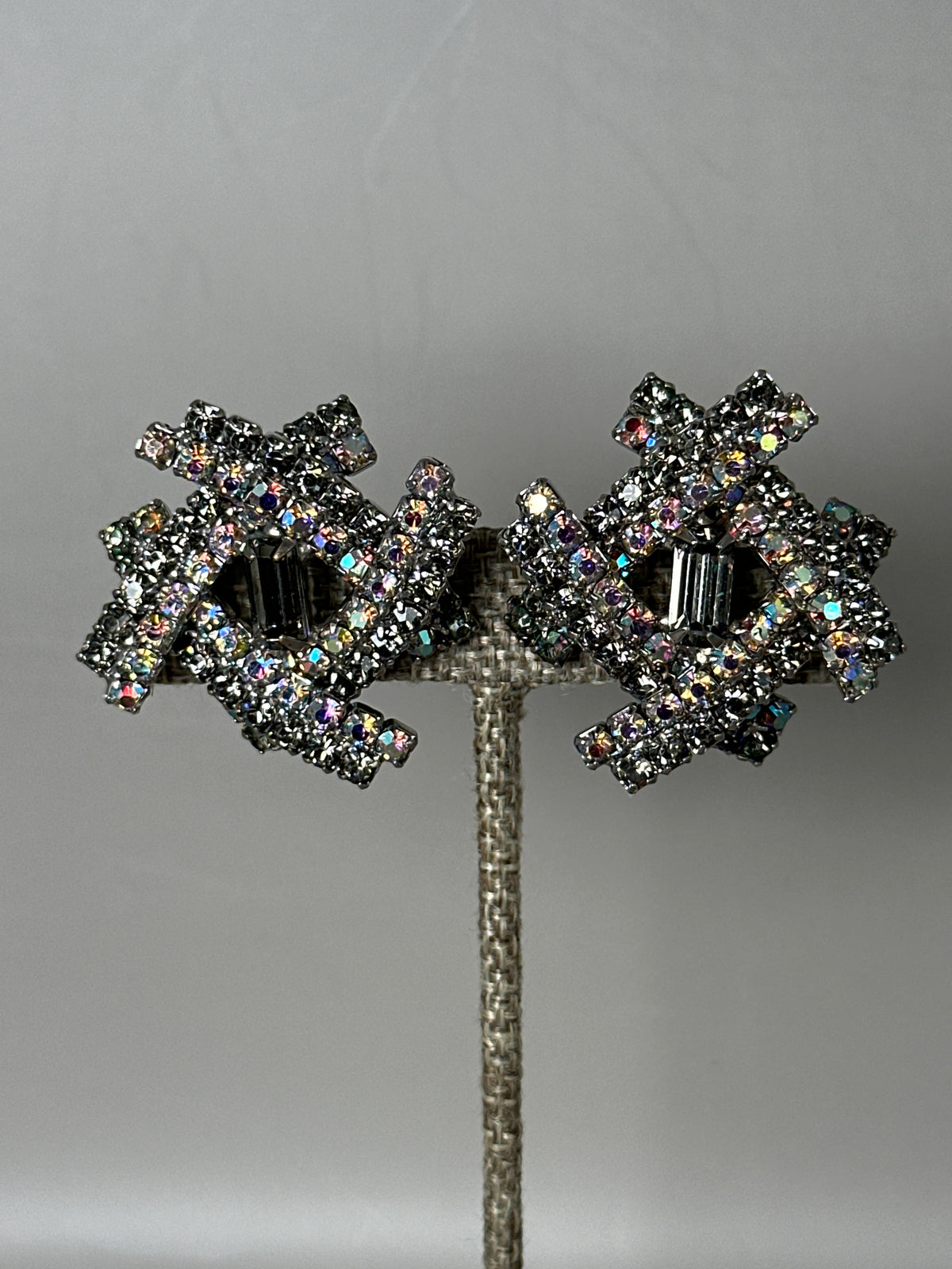 Matching clip earrings with AB and smoky rhinestones shown side by side, front view on display stand