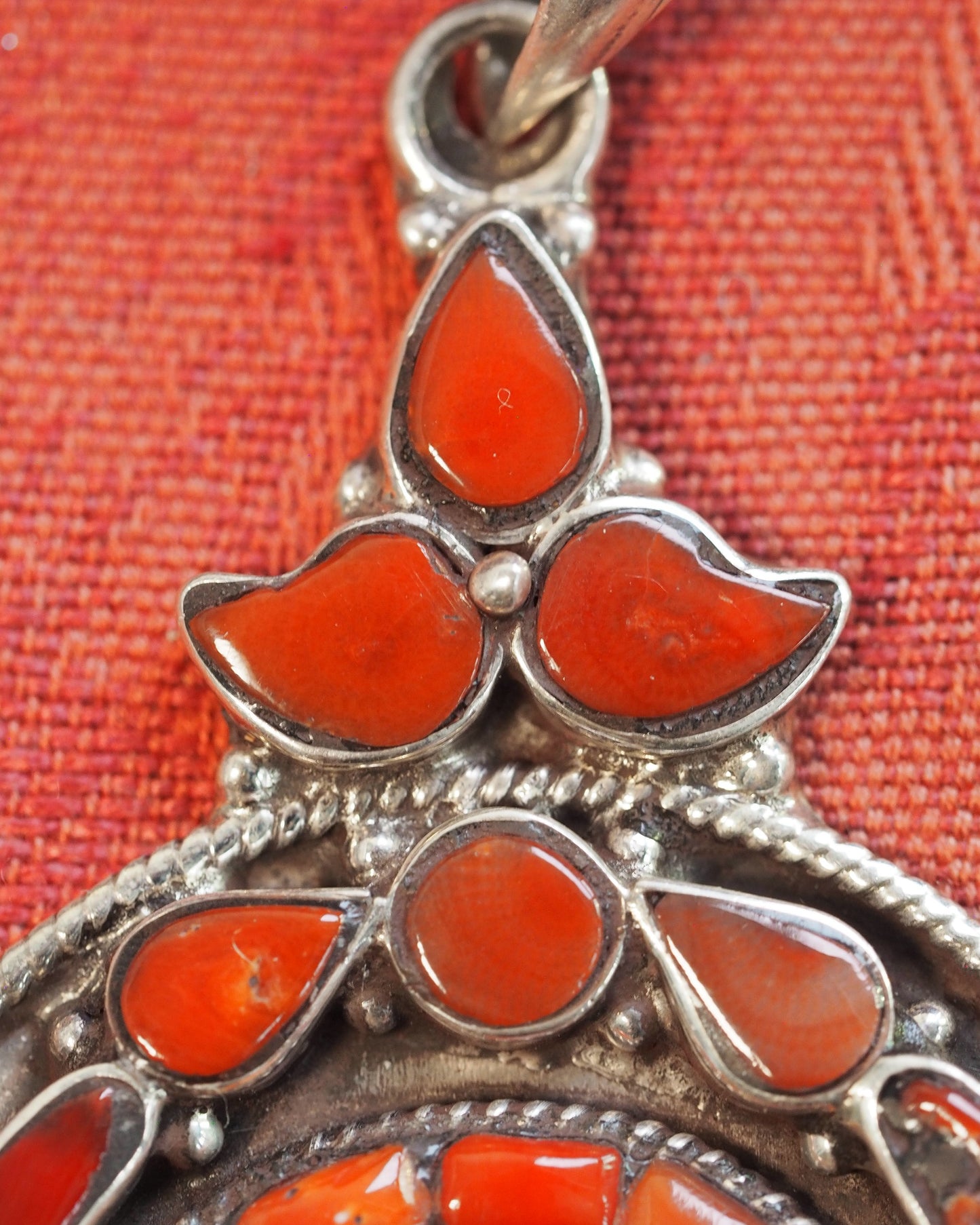 Close-up of three-petal coral cluster at pendant top, teardrop and fan-shaped bezels with applied silver balls