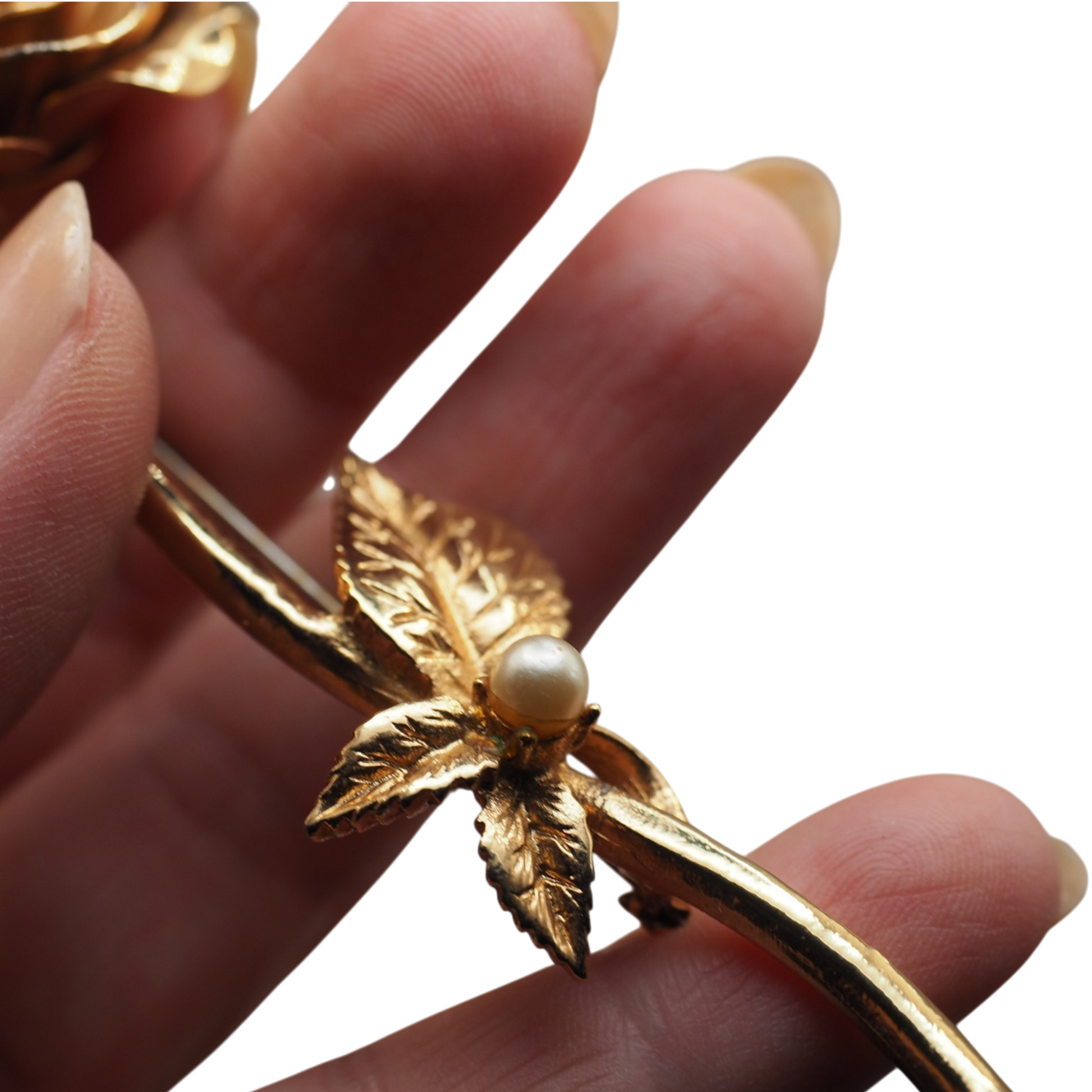 Back of a gold tone rose brooch showing the pin and clasp