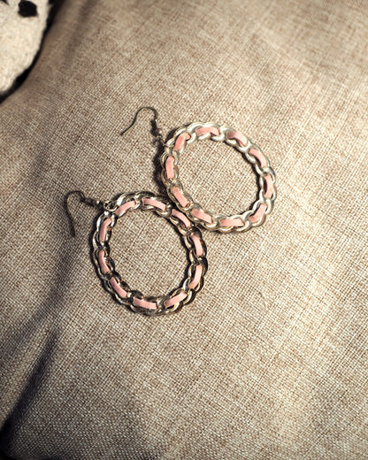 Close-up of 1970s pink enamel and silver-tone chainlink hoop earrings showing alternating enamel bars and curved metal links