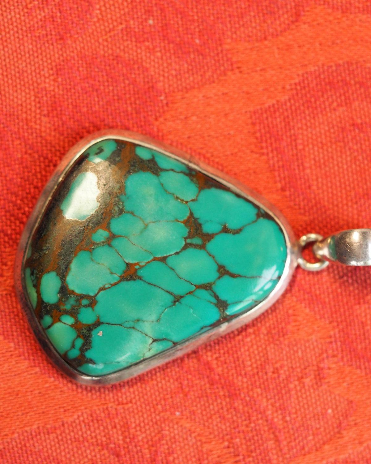 Sterling silver pendant with blue stone shown flat, bezel detail and matrix pattern visible