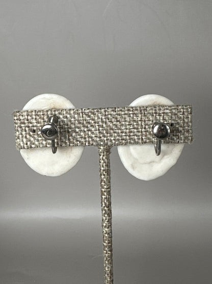Back view of white ceramic earrings showing silver-tone screw-back mechanisms