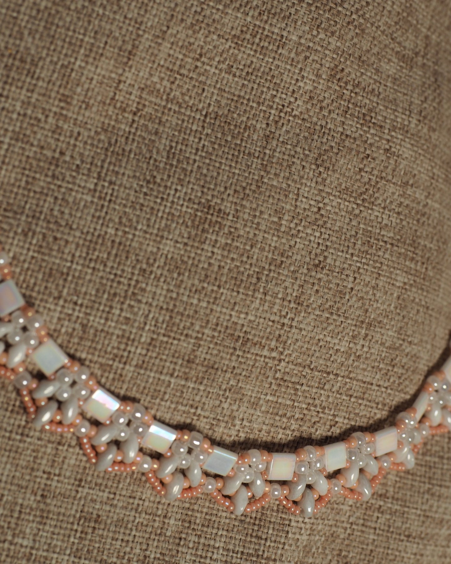 Lower section of collar necklace on burlap showing consistent beadwork pattern and spacing