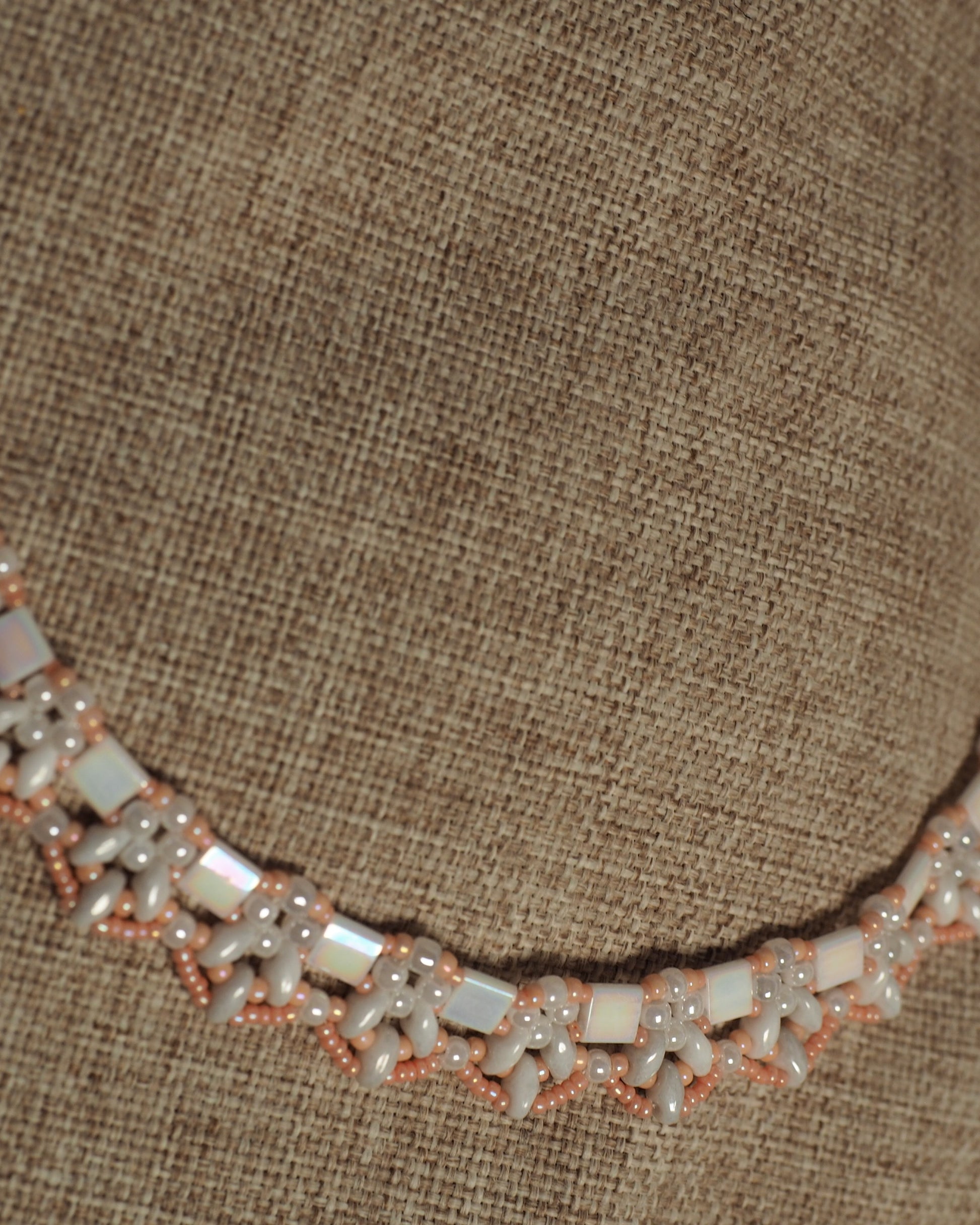 Lower section of collar necklace on burlap showing consistent beadwork pattern and spacing