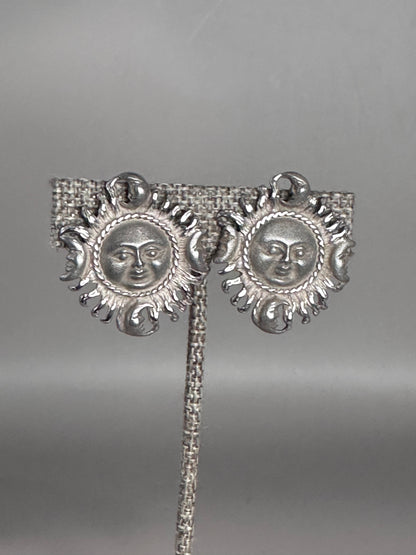 Sterling silver Taxco sun and moon clip earrings shown from the front, each featuring a sun face surrounded by radiating rays with four crescent moons