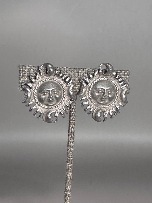 Sterling silver Taxco sun and moon clip earrings shown from the front, each featuring a sun face surrounded by radiating rays with four crescent moons