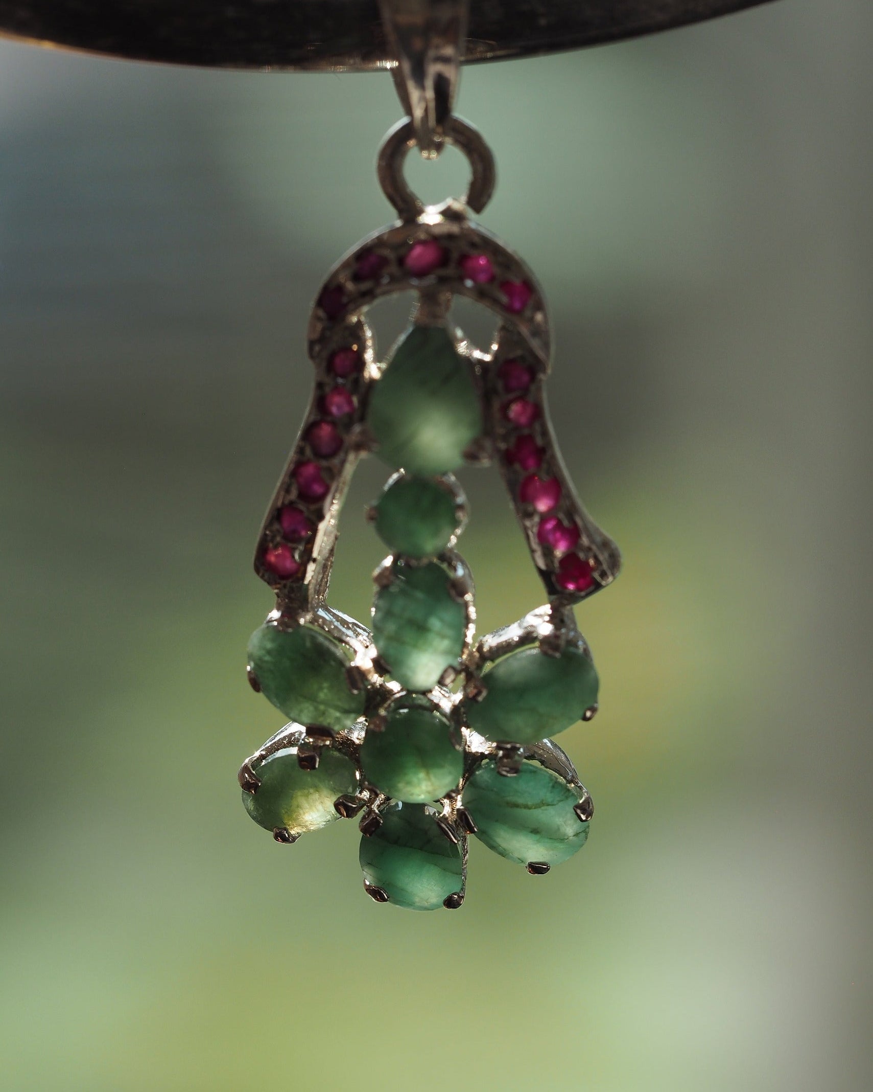 Sterling silver green and red stone flower pendant, angled side view showing openwork basket construction