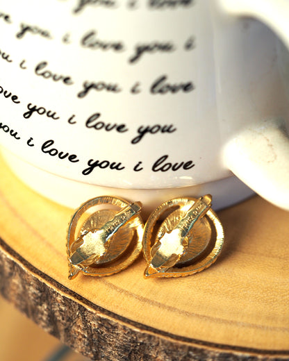 Reverse view of both Trifari clip earrings showing hinged clip mechanisms and Trifari signature stamps on the clip bars