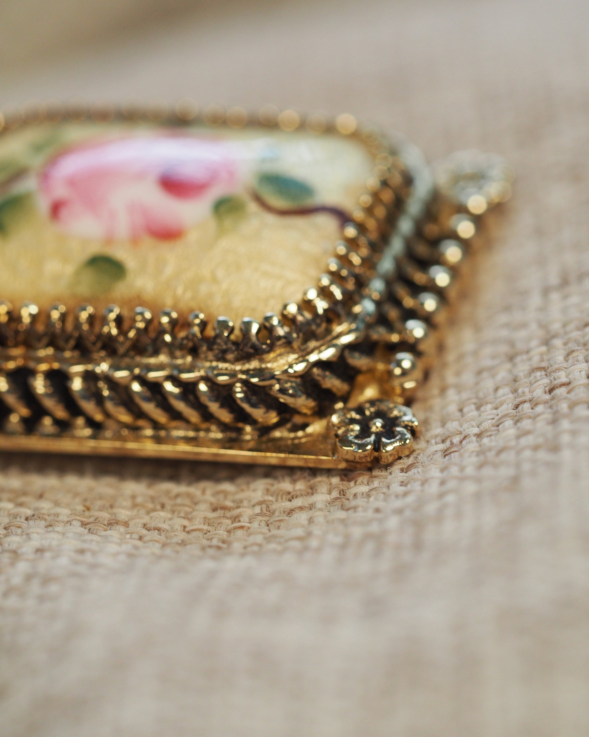 Close-up of corner flower appliqué and beaded frame detail on one earring