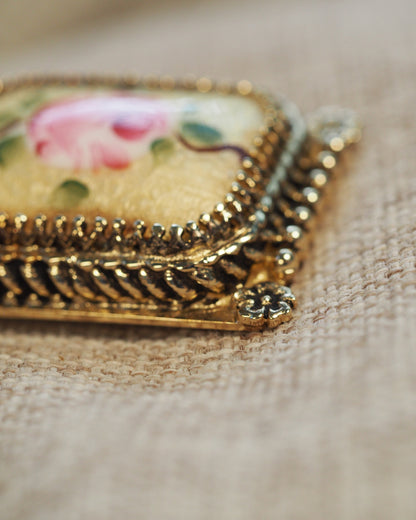 Close-up of corner flower appliqué and beaded frame detail on one earring