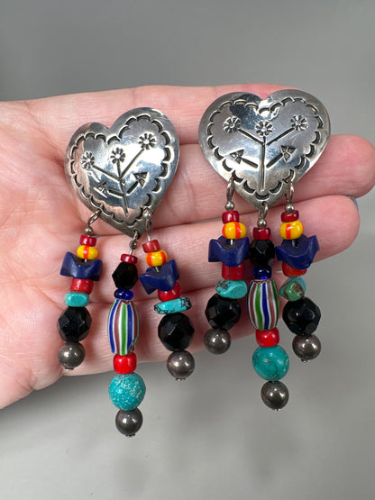 Taxco heart earrings held in hand for scale, showing 2.75-inch length with turquoise, black, and chevron glass beads