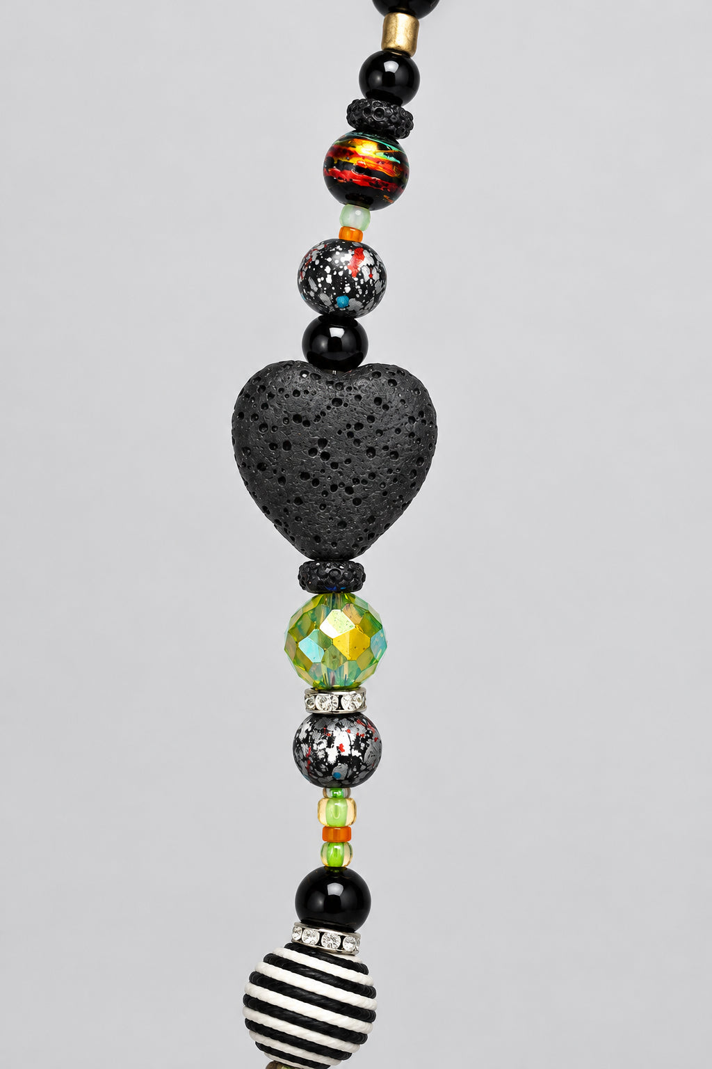 Black lava stone heart bead between faceted glass beads on Halloween necklace